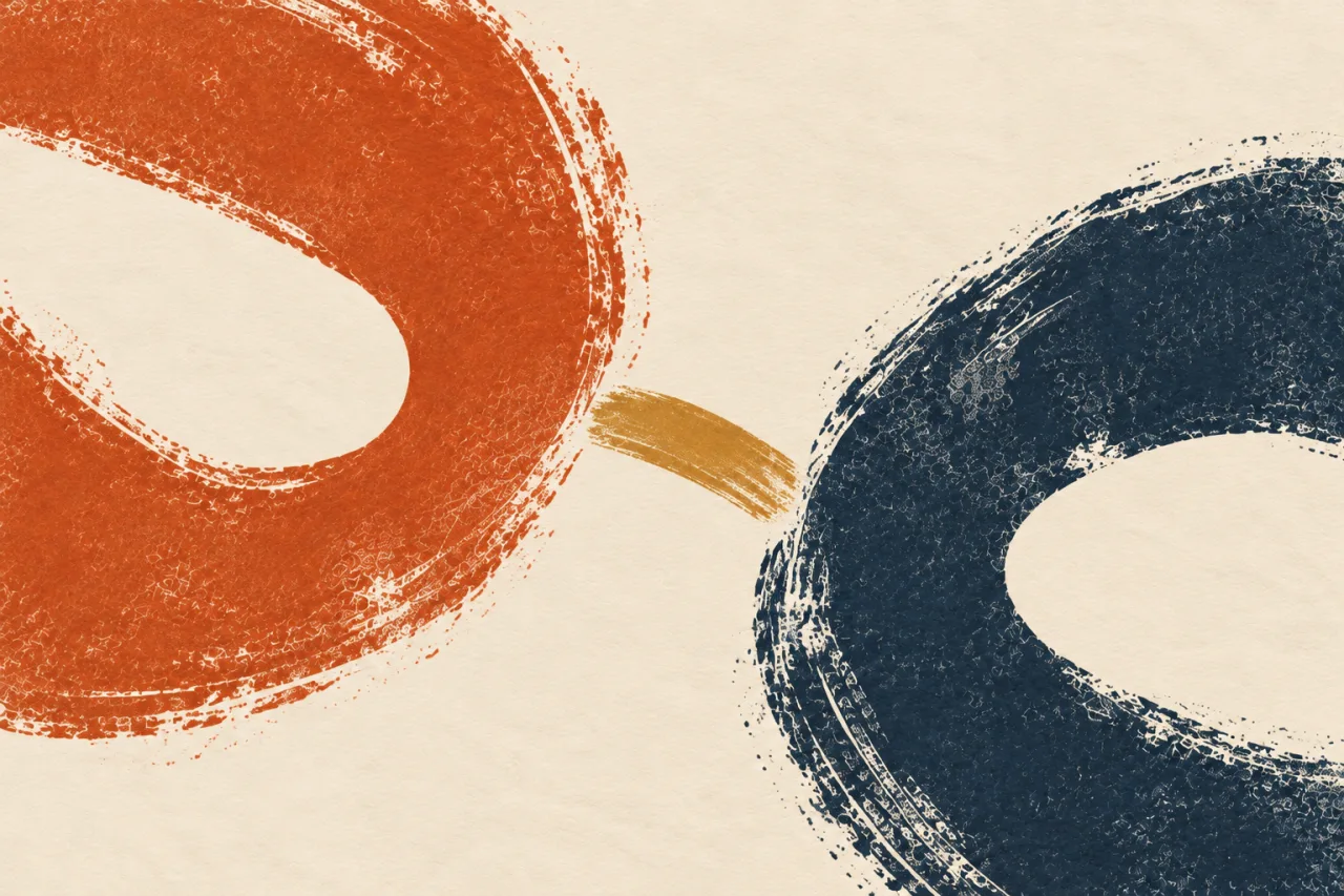 Dois anéis abertos texturizados, um laranja e outro azul-escuro, são unidos por uma pequena ponte ocre sobre fundo creme.